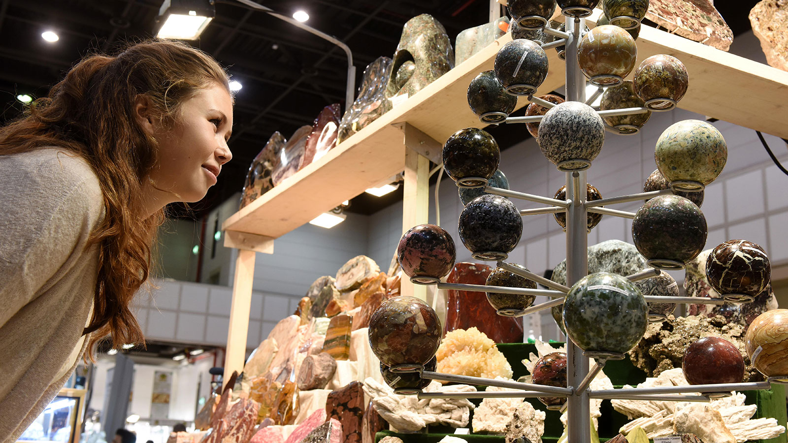 A female visitor standing in front of minerals at the Mineralien Hamburg trade show in the Hamburg exhibition halls